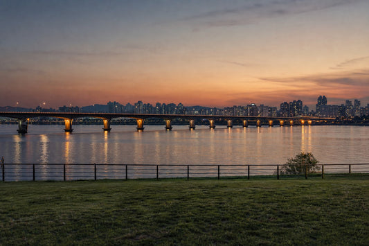 The Han River in Seoul at dusk with a lit bridge